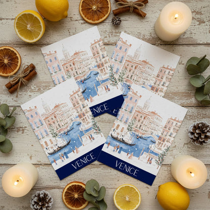 Venice-themed greeting cards on a wooden surface with candles and citrus fruits.