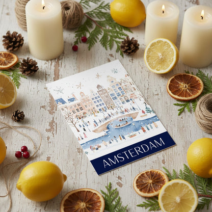 Greeting card with Amsterdam design surrounded by lemons, candles, and pine cones on a wooden surface.